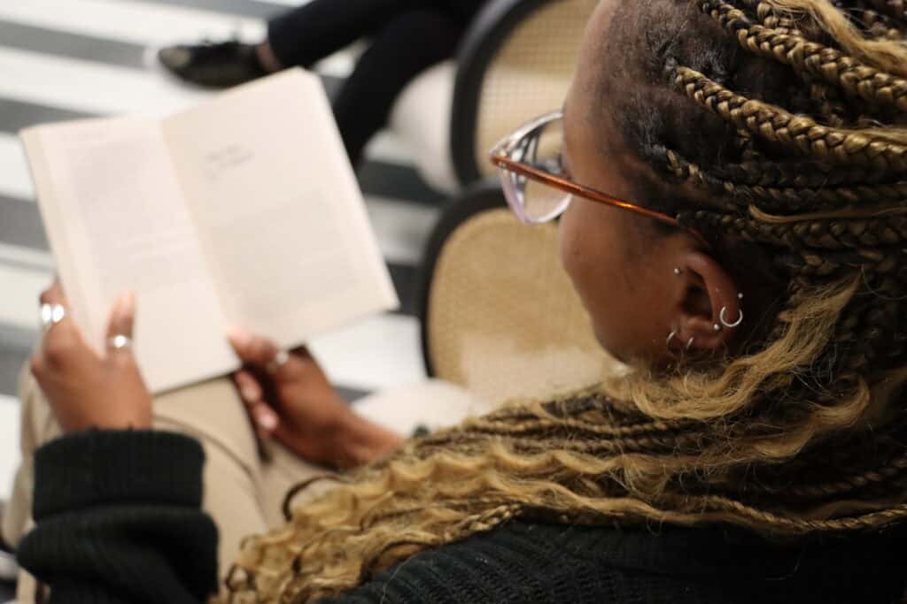 Image taken over the shoulder of a woman reading a book